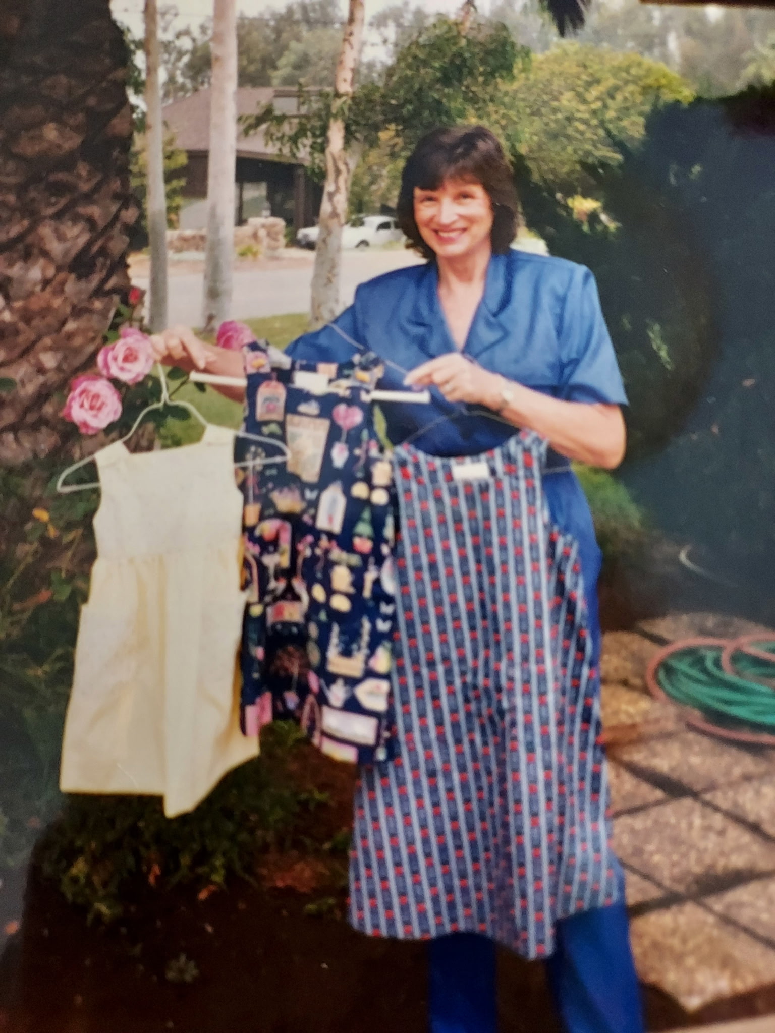 Gamma holding some of the dresses she's made over the years