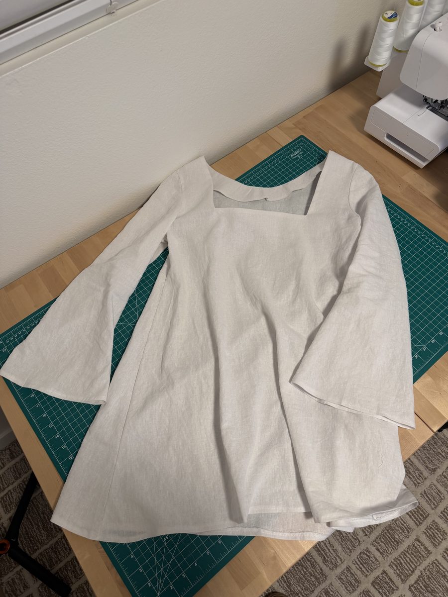 Finished white linen mini dress laid out