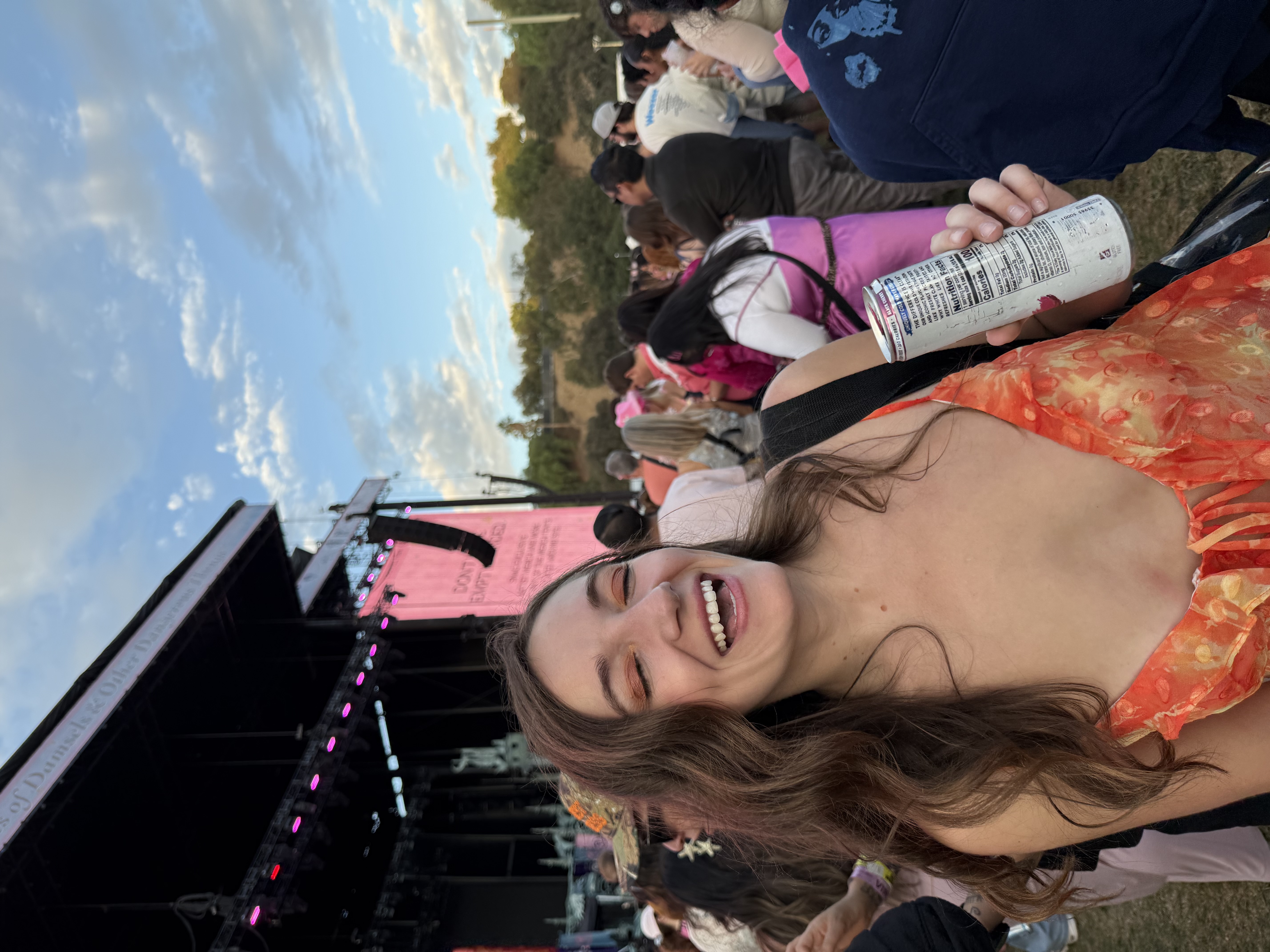 Emily at the Chappell Roan show smiling with the stage in the background