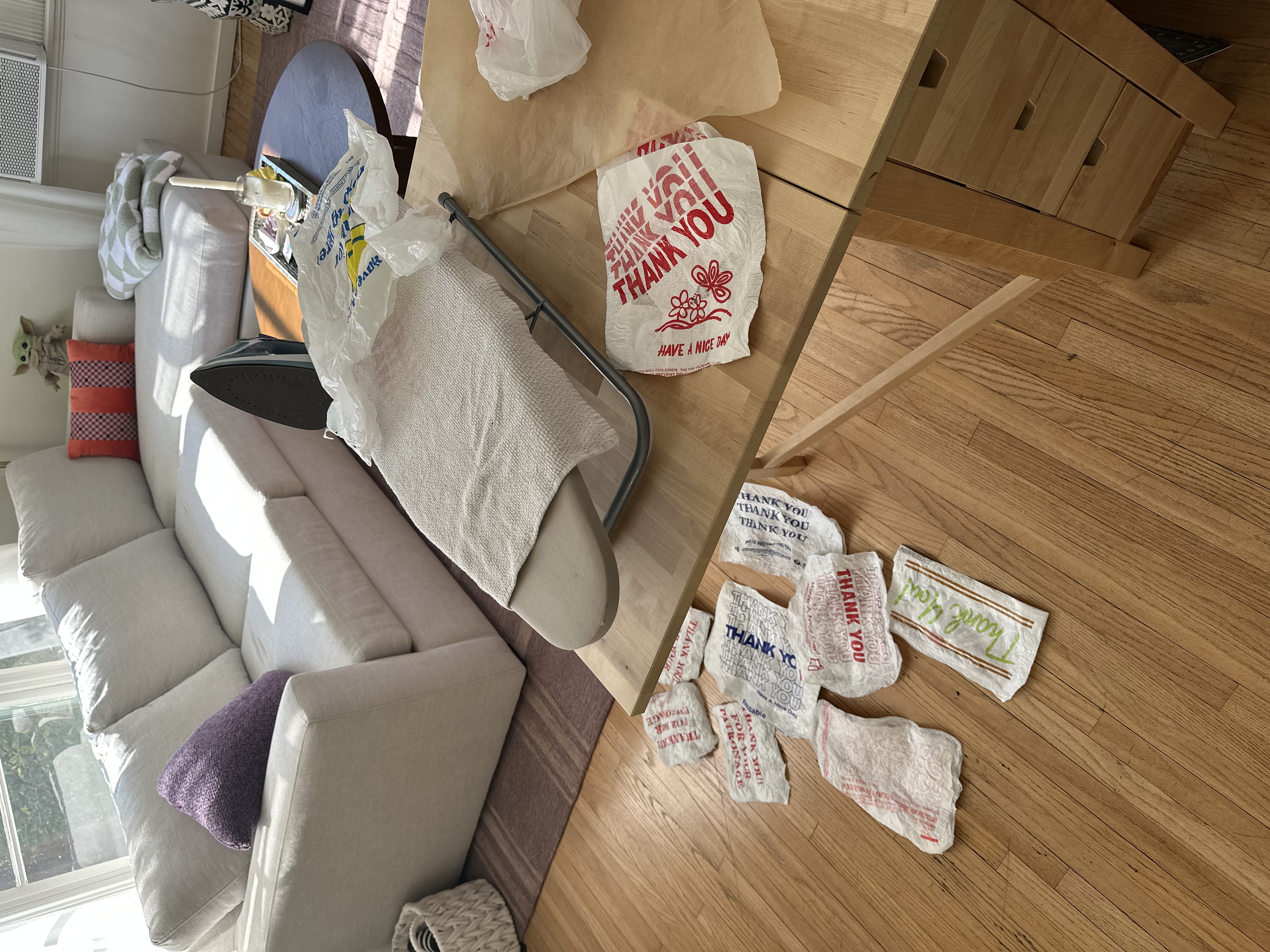 Emily ironing plastic bags between parchment paper to fuse them into a sheet
